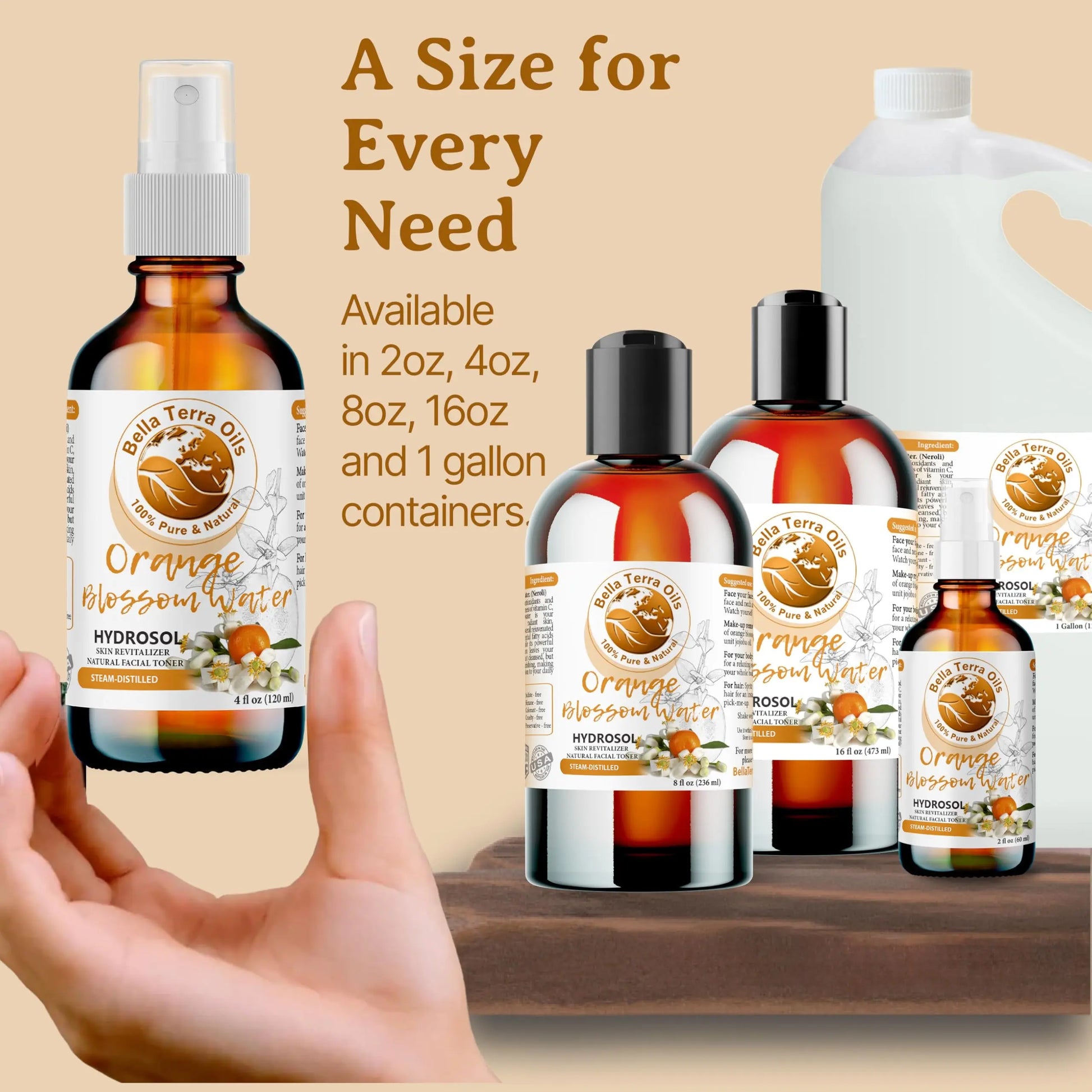 Collection of Orange Blossom Winter hydrosol bottles in various sizes with a hand holding one bottle.