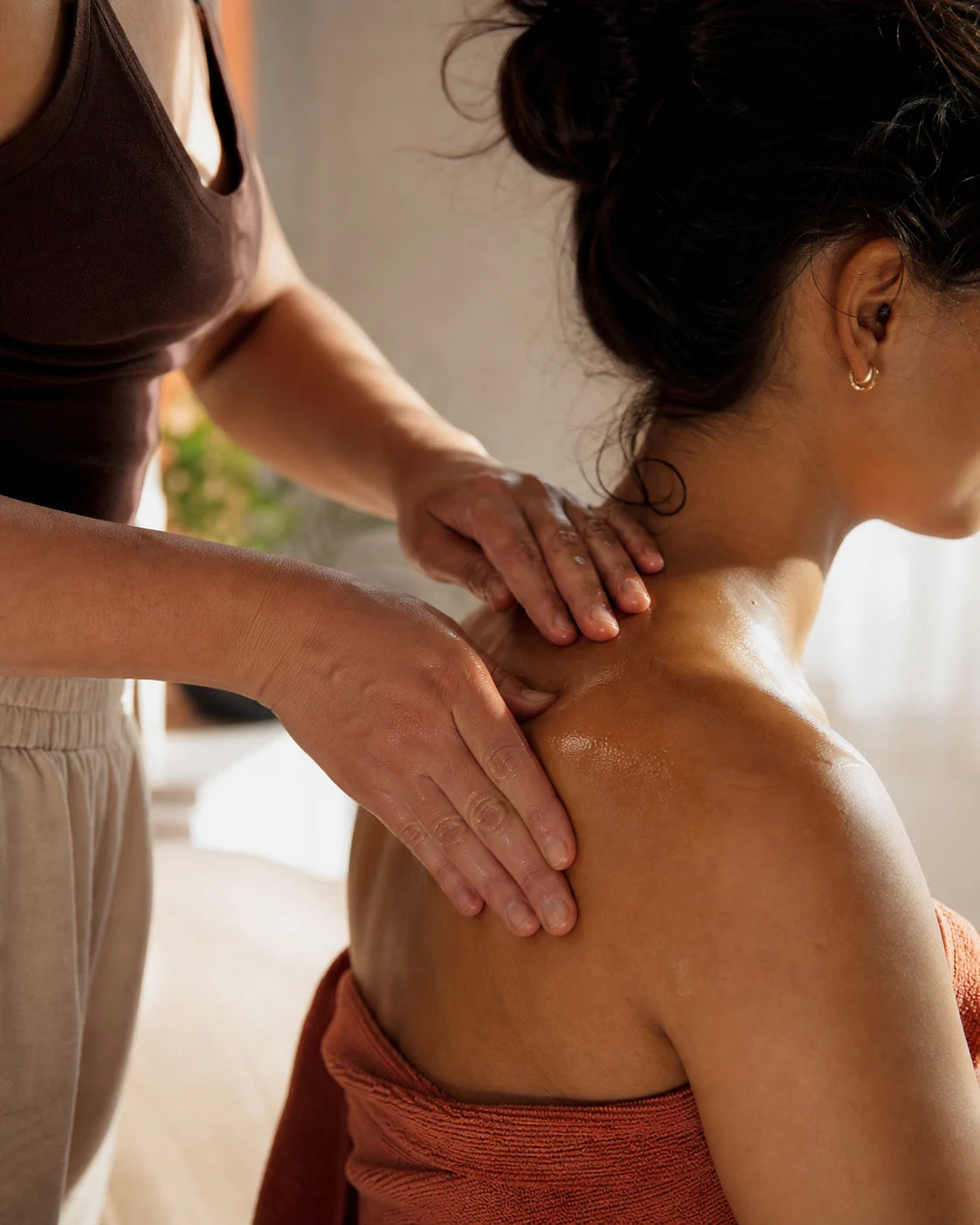 Botanical oil being used during a warm at-home shoulder massage