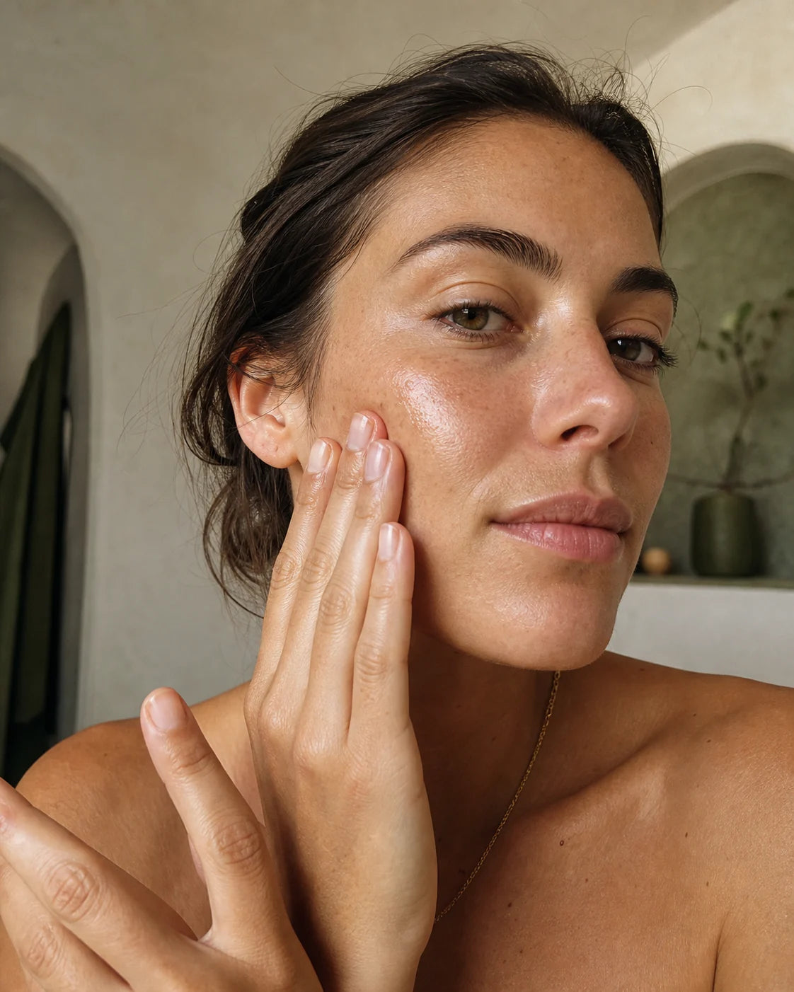 Woman gently pressing botanical oil into her cheek